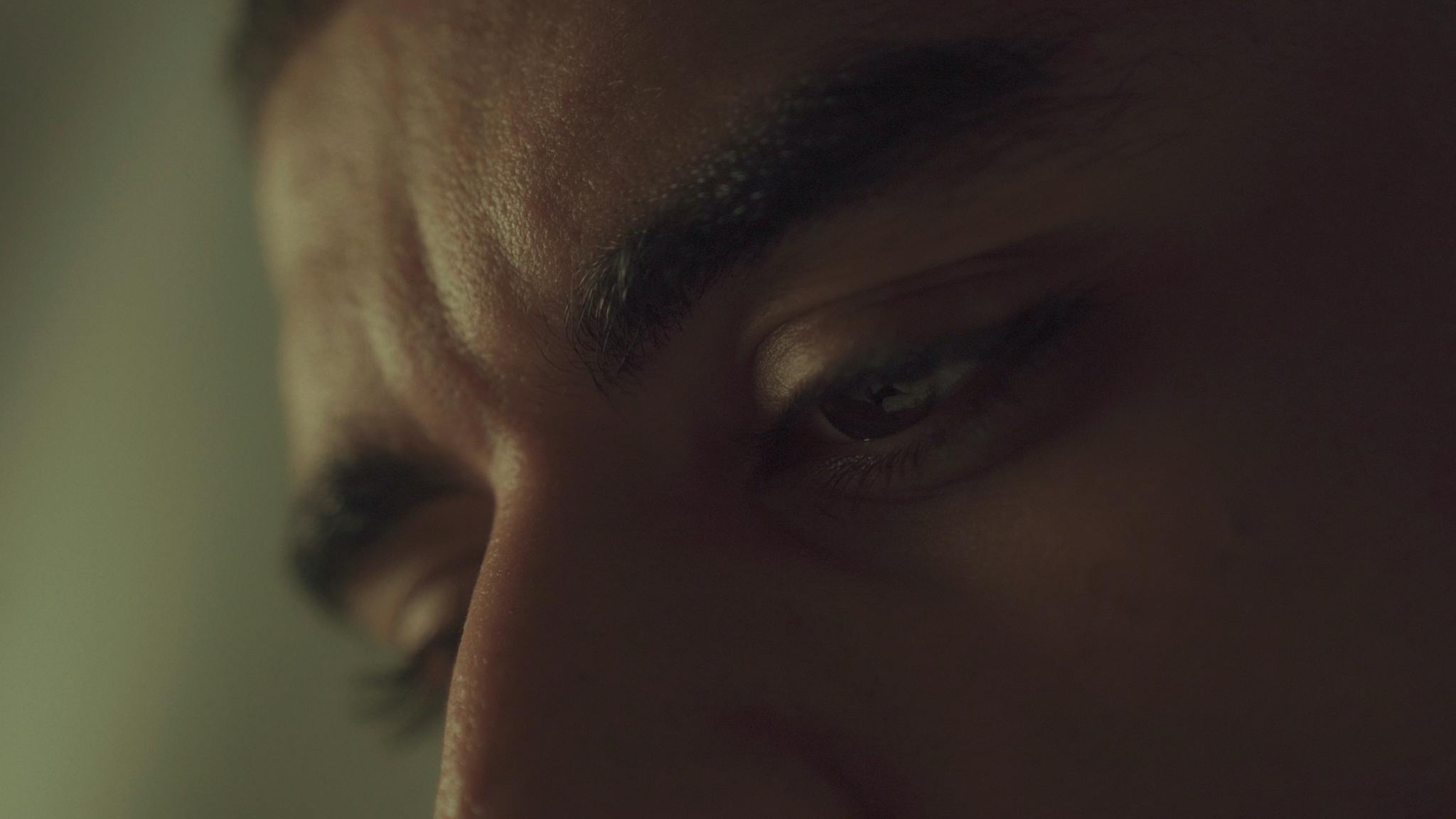 A close-up portrait of a person in deep thought with dramatic, moody lighting.