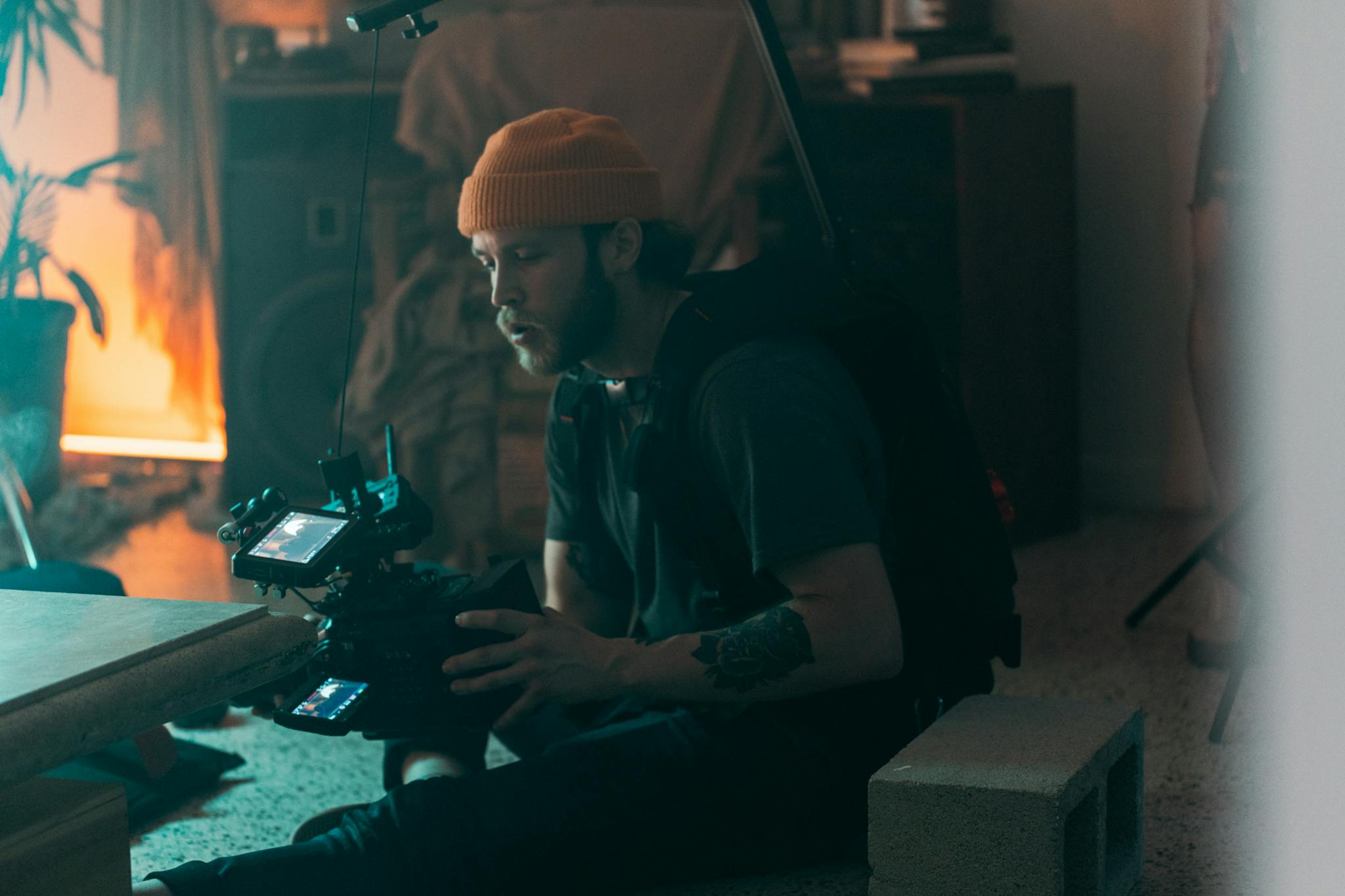 Professional cinematographer working indoors with camera gear, showcasing concentration and creativity during filming.